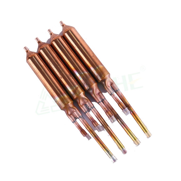 Four copper filter driers used in HVAC systems for moisture and debris removal from refrigerant lines.